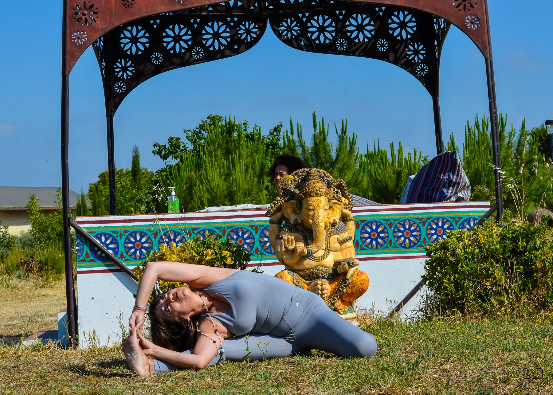 Pilar Valencia practicando yoga al aire libre junto a una figura de Ganesha