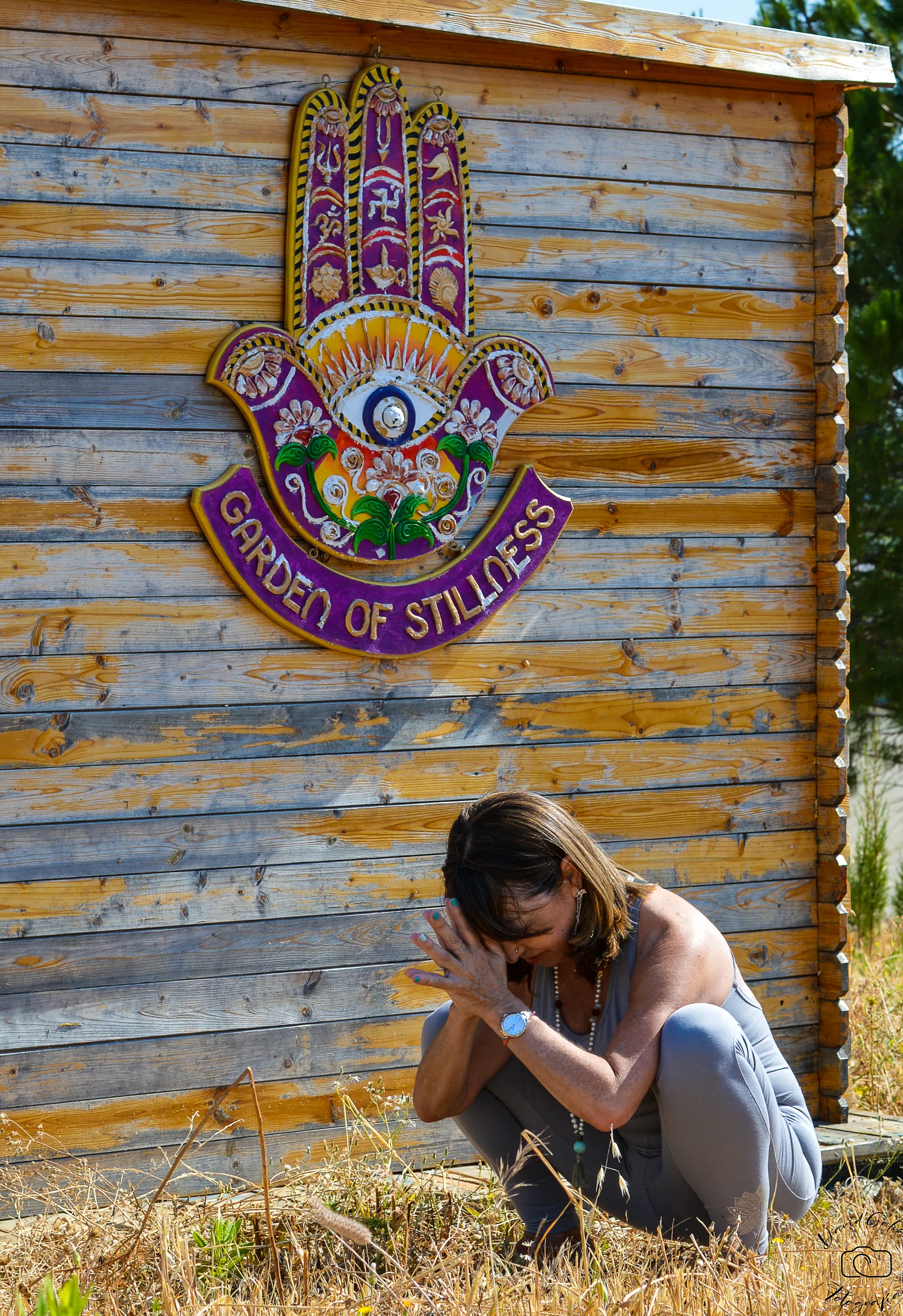 Grupo de alumnos en meditación dentro de una sala con mural colorido