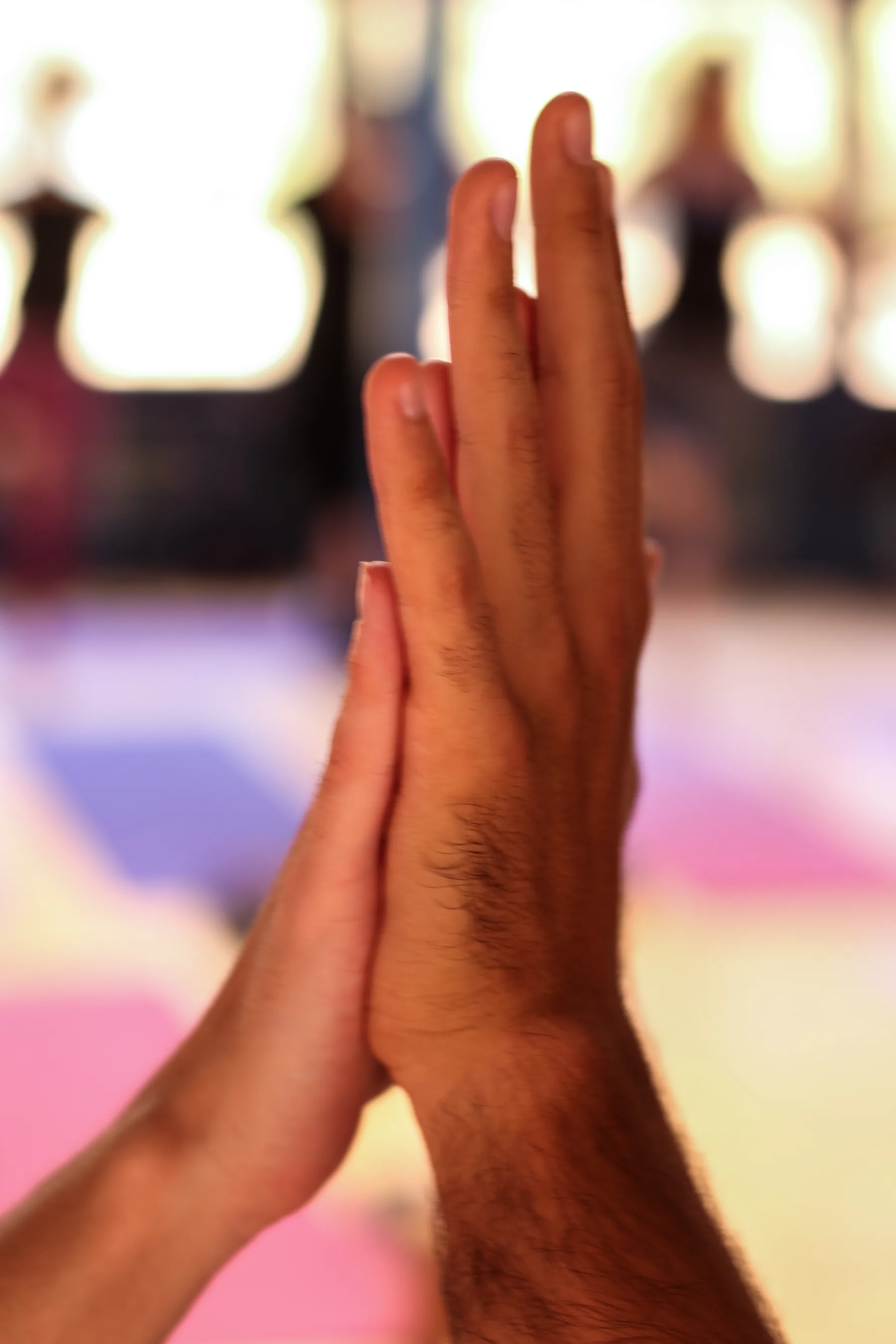 Detalle de dos manos encontrándose durante una práctica de yoga